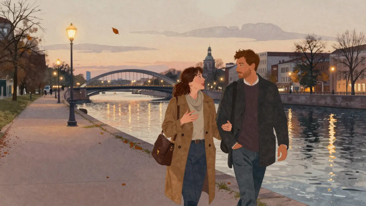 A couple strolls along the Spree River in Berlin at dusk, city lights reflecting on the water.